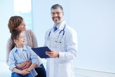 Girl and mother looking at  doctor