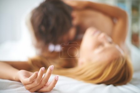 Female lying on bed with man