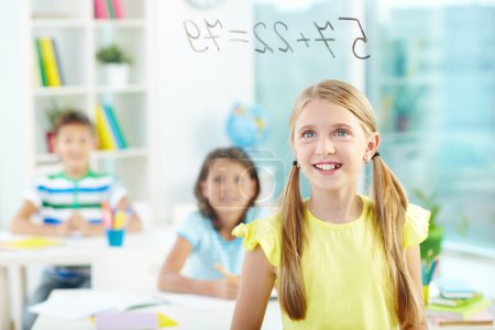 Girl looking at sums on transparent board