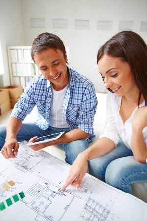Couple discussing plan of new flat