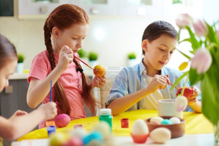 Preschoolers painting eggs