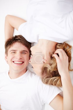 Couple lying in bed and laughing