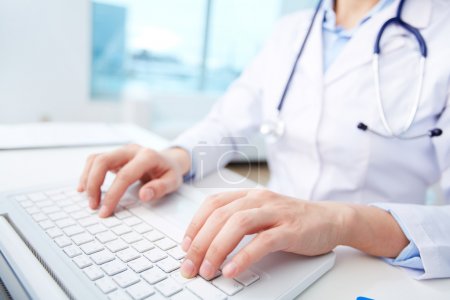 Medical worker typing on laptop