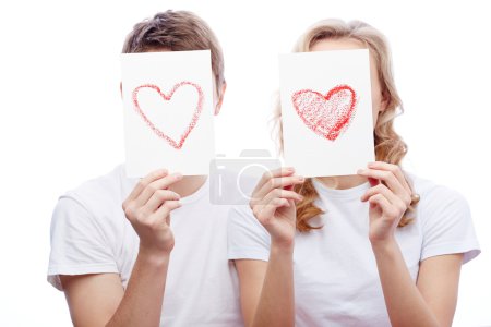Couple holding papers with red hearts