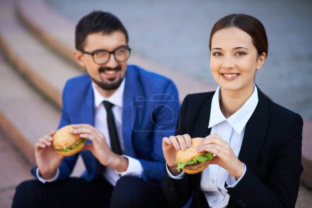 Colleagues eating sandwiches