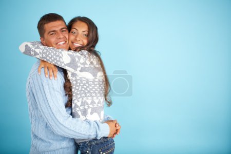 Couple in fashionable pullovers embracing