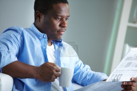 African man reading news