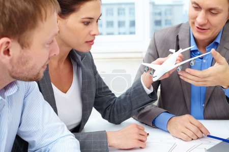 Engineers discussing small model of plane