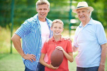 Boy with rugby ball, grandfather and father