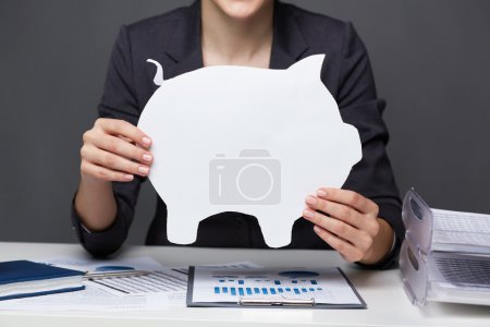 Businesswoman holding paper piggy