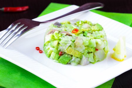 Elegant salad Tartar with herring, avocado, lettuce, restaurant