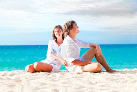 Young happy couple having fun on tropical beach. honeymoon