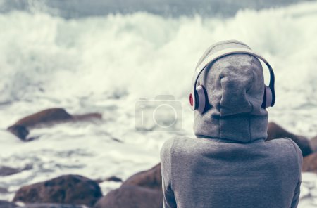 girl listening to music on the seafront