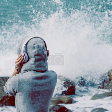 girl listening to music on the shore