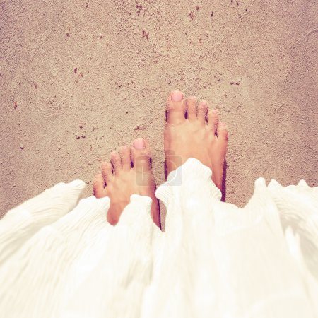 Woman feet closeup relaxing on beach