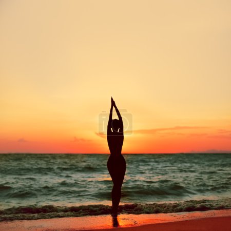 Beautiful slim girl at sunset on the beach