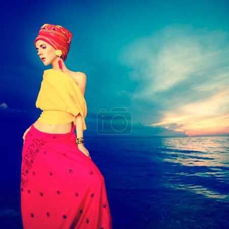 Sensual girl in oriental style on the beach at sunset