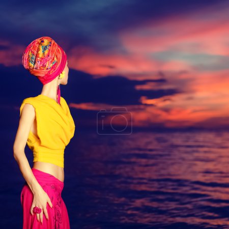 Sensual girl in oriental style on the beach at sunset