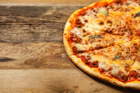 Bolognese pizza on wooden table.