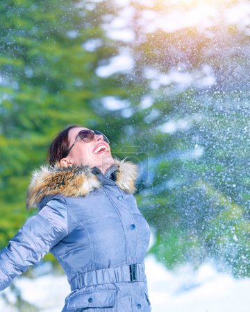Happy woman throwing snow