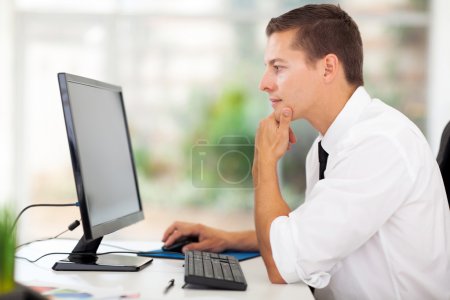 young businessman looking at computer screen