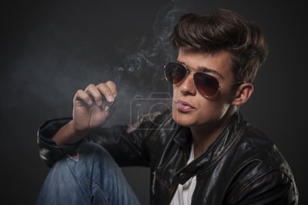 Portrait of young man wearing sunglasses and smoking