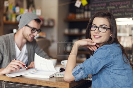 Woman studying with her friend at cafe