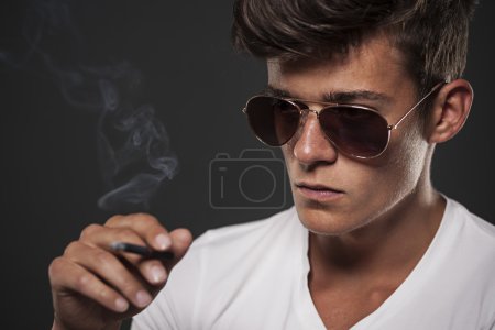Focus young man with black cigarette