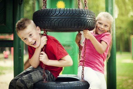 Little girl and boy having fun on playground