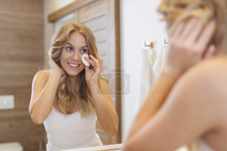 Blonde woman cleaning face