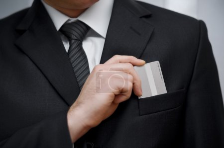 Businessman putting his credit card in pocket