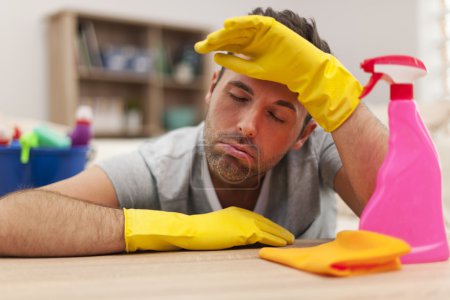 Tired man with cleaning equipment