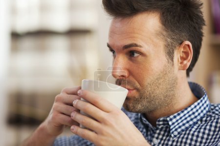 Man drinking coffee in home