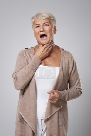 Senior woman has with sore throat
