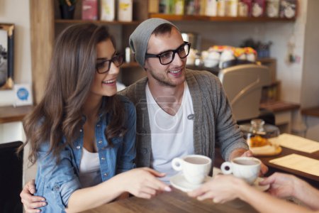 Fashion couple receiving cup of coffee