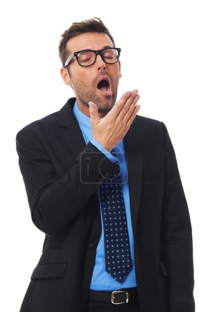 Businessman covering mouth and yawning