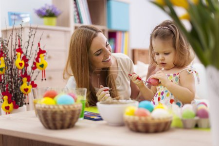 Mother and baby painting easter eggs