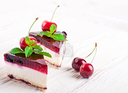 Cherry cheesecake with tea on a wooden table