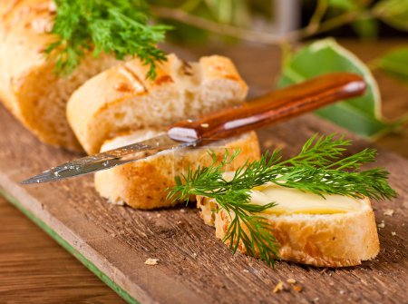 Fresh bread and butter on a wooden board