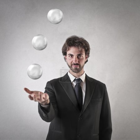 Businessman throwing up some crystal balls