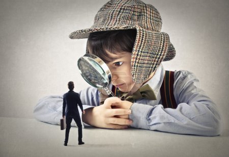 Child looking at a businessman through a hand lens
