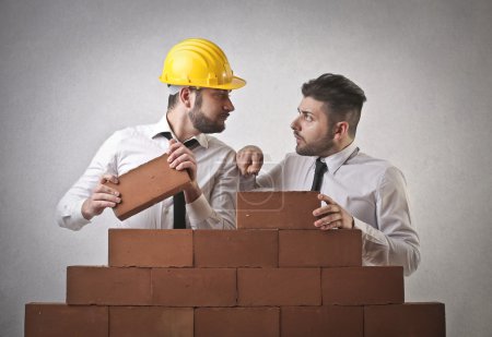 Businessman trying to build a wall