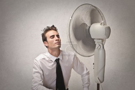 Businessman in front of a fan