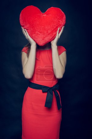 Pretty woman squeezing Valentine heart in her arms