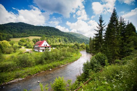 Rural view with river and single house in Bieszczady mountains, Poland