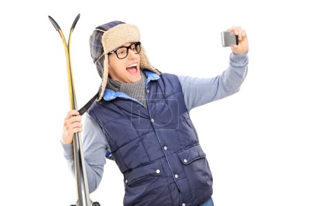 Man taking selfie with skis