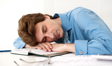 Tired Businessman Sleeping At Workplace In The Office