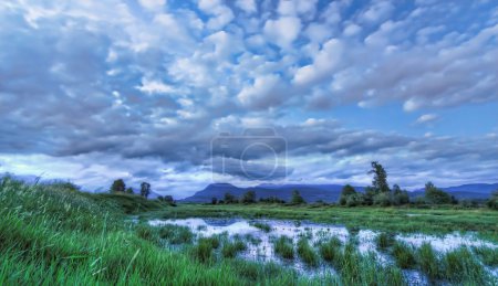 Blue Landscape with Dramatic Clouds Mountain and Water