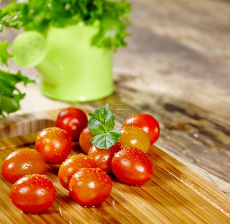 Cherry tomatoes with basil on a wood table
