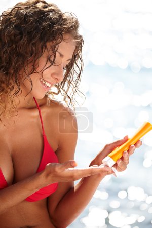 woman in bikini smear protective cream on the skin